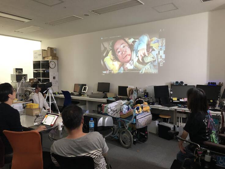 報告会でスライドを見ている様子