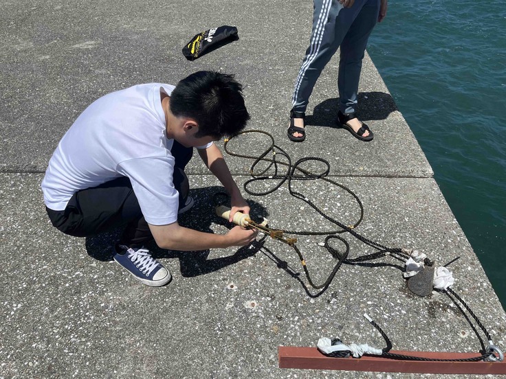 水中マイクをロープから取り外している様子