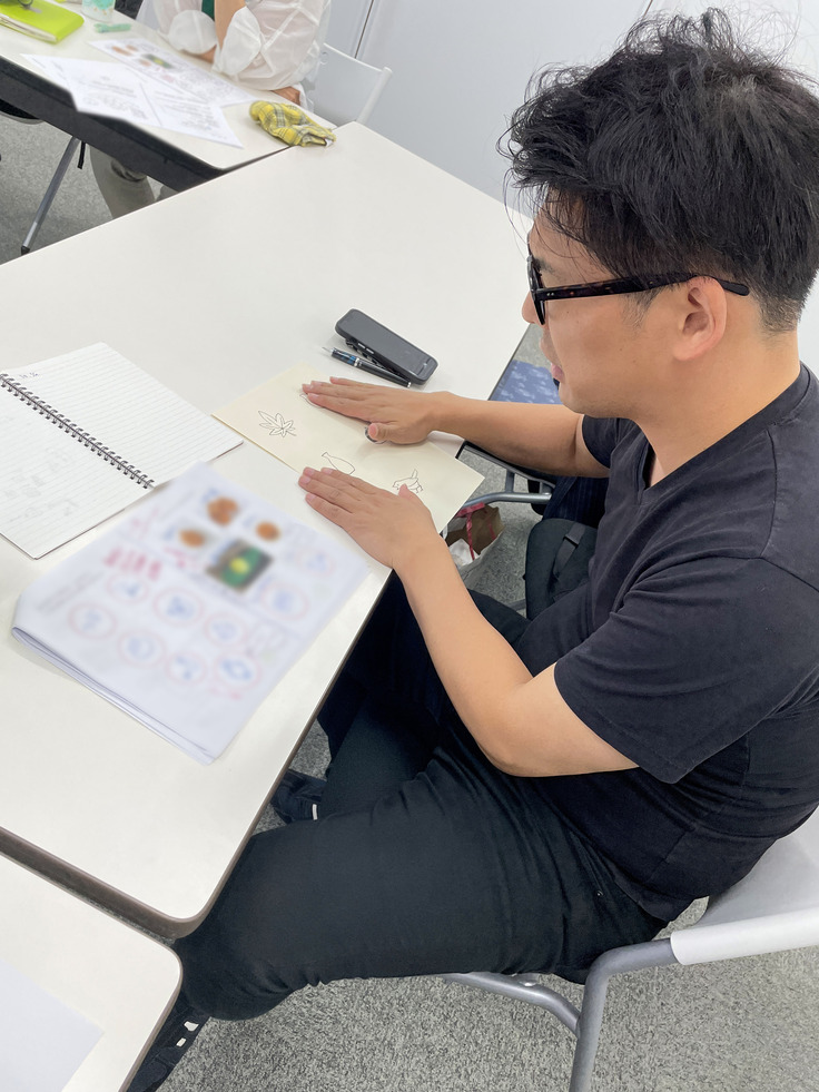 触って楽しめる絵（触図）を触ってみている昇吉