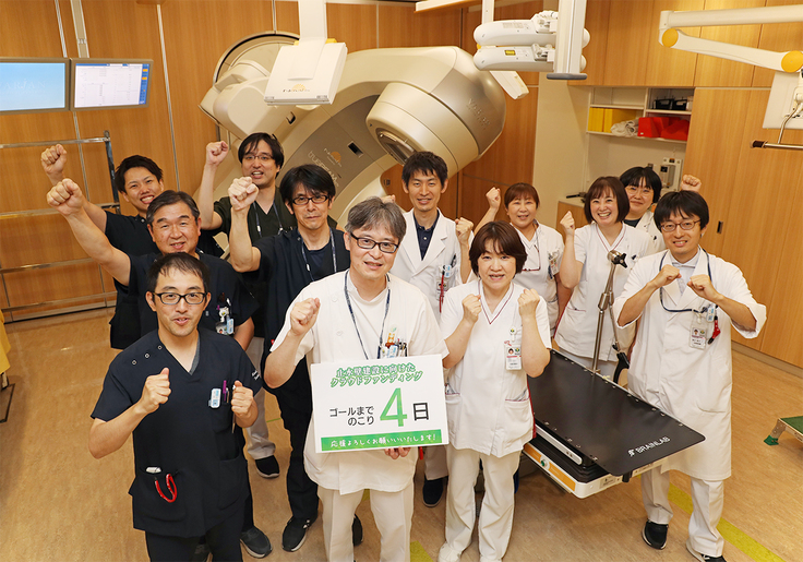 放射線治療センター内　外部放射線治療装置 TrueBeam STx の前にて