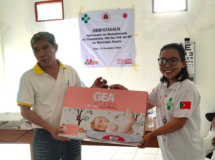 写真：アタウロ保健センターへ機材供与（左=県代表、右=シェア職員）