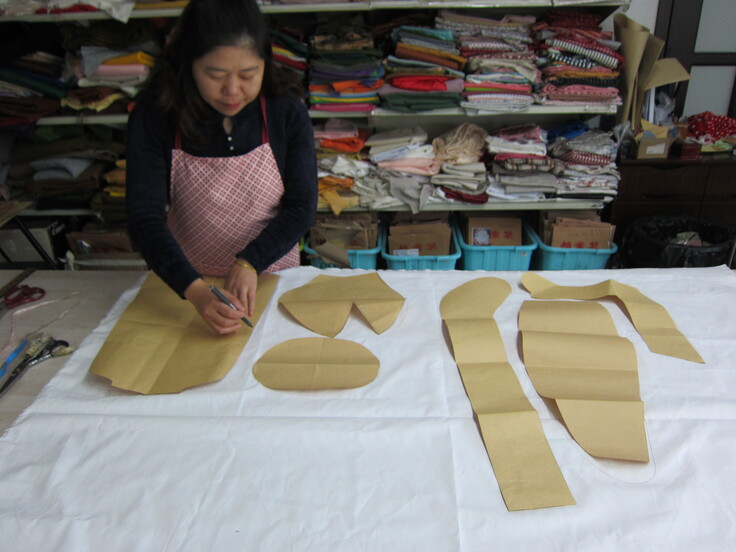 生地に型紙をあてて裁断線を書いています