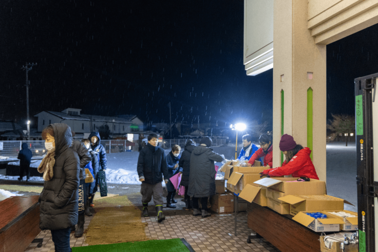 雪の降る中、届いた支援物資を配布