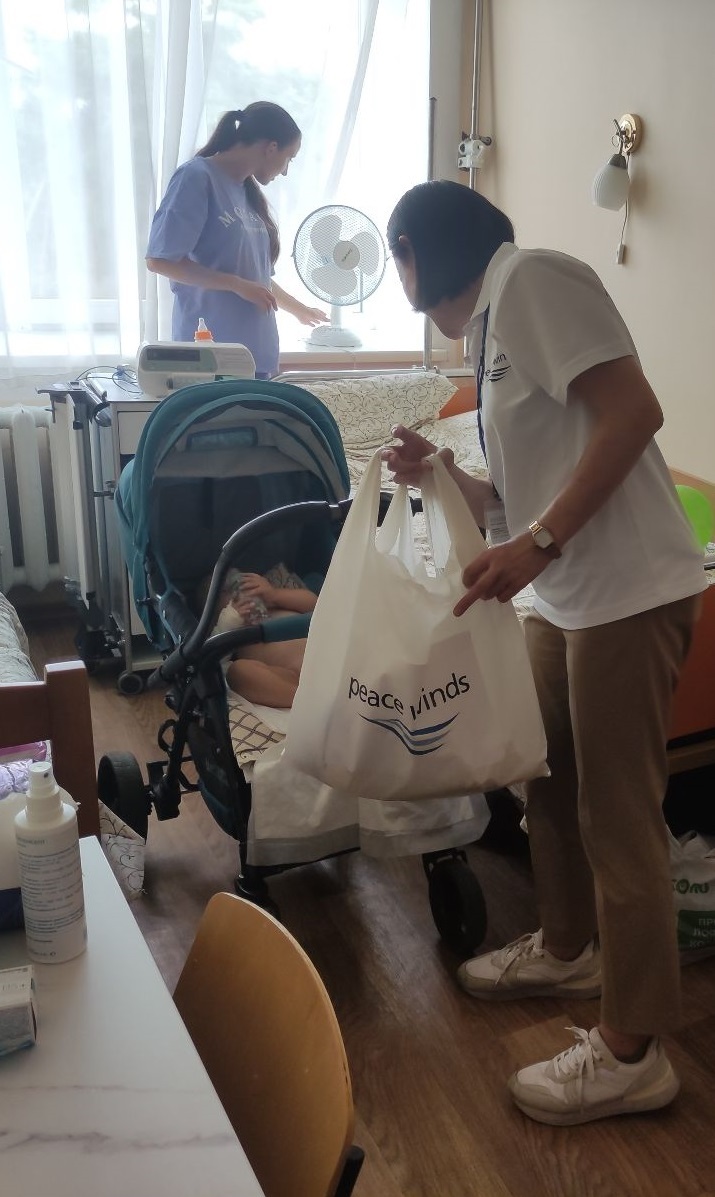 ピースウィンズが届けた扇風機を使う母親