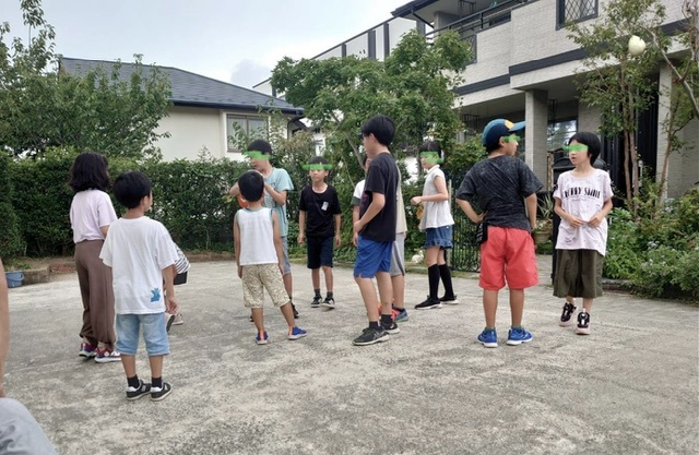 缶蹴り遊びをする子ら