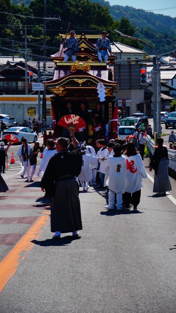 国道８号線を渡り、曳山が跨線橋を登り始めたところ。
