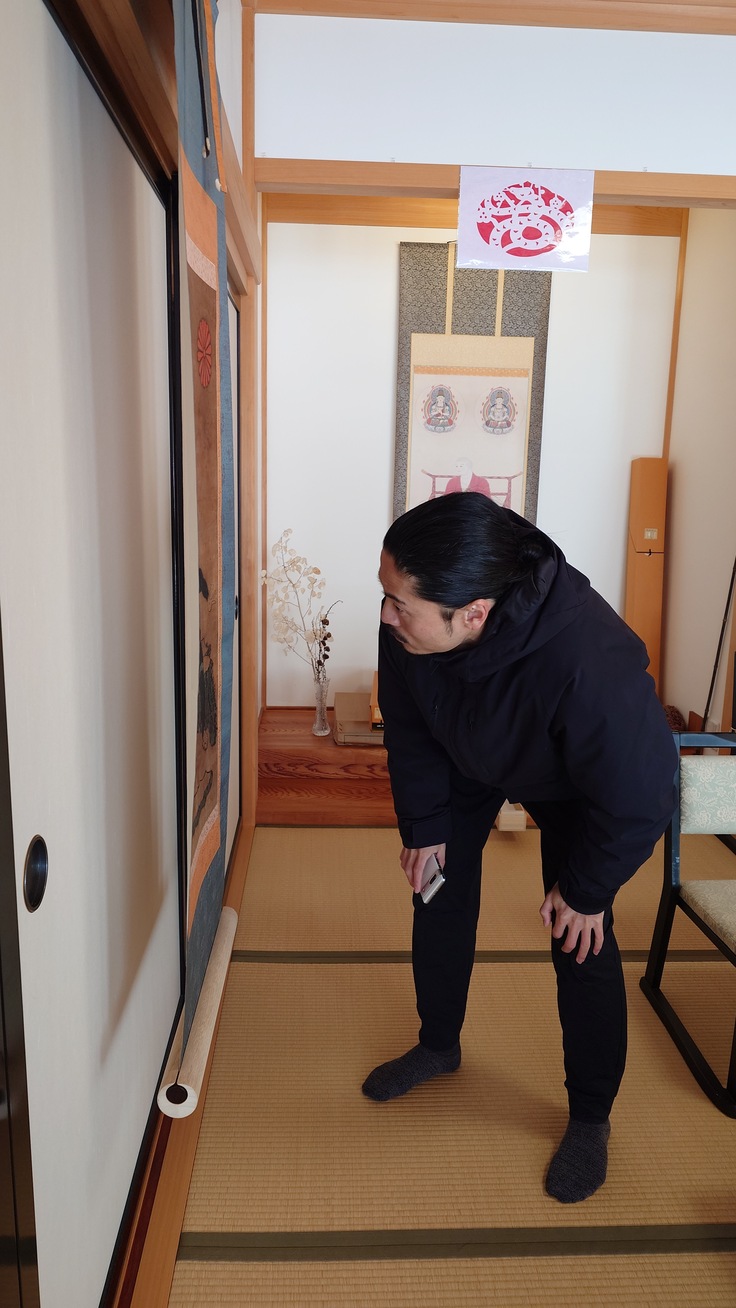 護法善神の掛け軸を細部まで確認する宮本仏師
