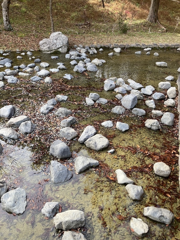 公園の中の小川に小石が点々と並んでいる写真