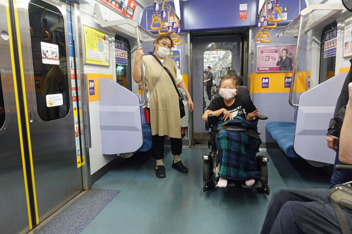 宿泊プログラム参加者の障害当事者と介助者が電車に乗っている様子