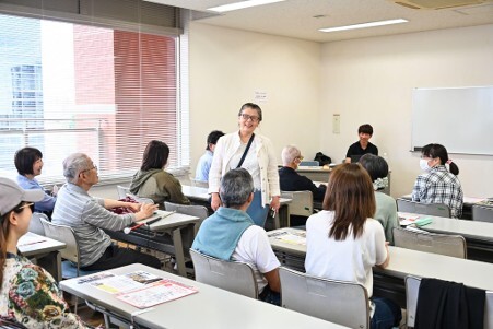 参加者の女性が後ろを向いて全体に感想を話している様子