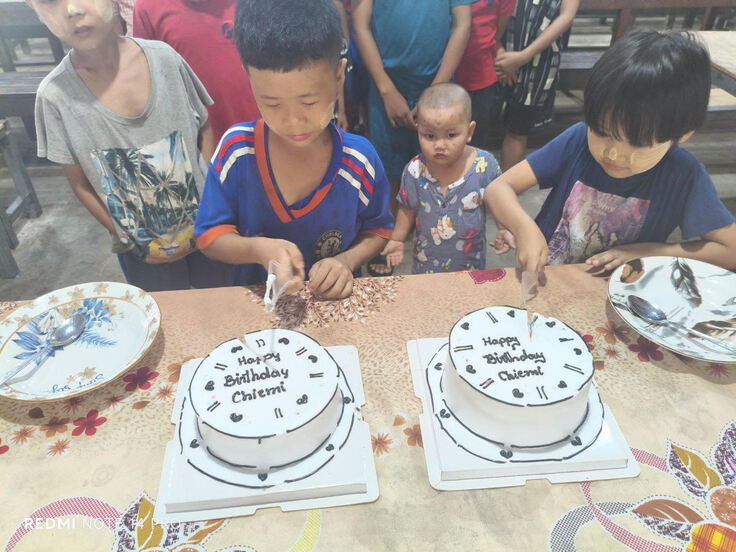 孤児院での誕生日ケーキを切り、お互いにケーキを食べ合う