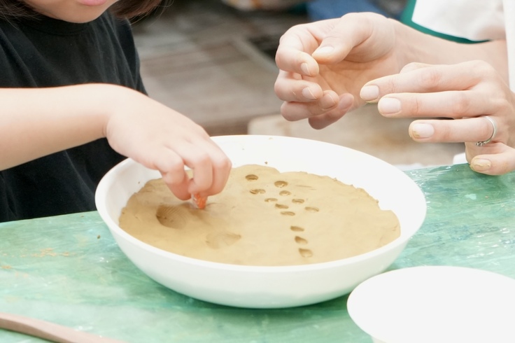 粘土に型押しをする子ども