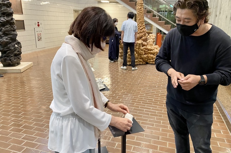 松前記念館で鑑賞者に語りかける篠原聰先生（右）