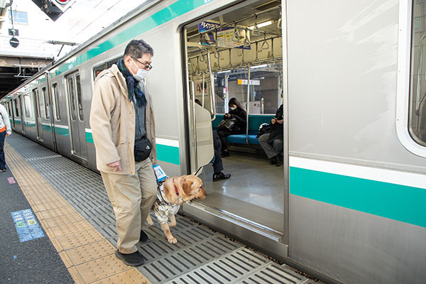 盲導犬と電車に乗る松井氏