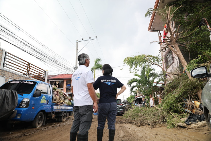 被災から数日が経過しても引かない泥水の中を歩いて調査